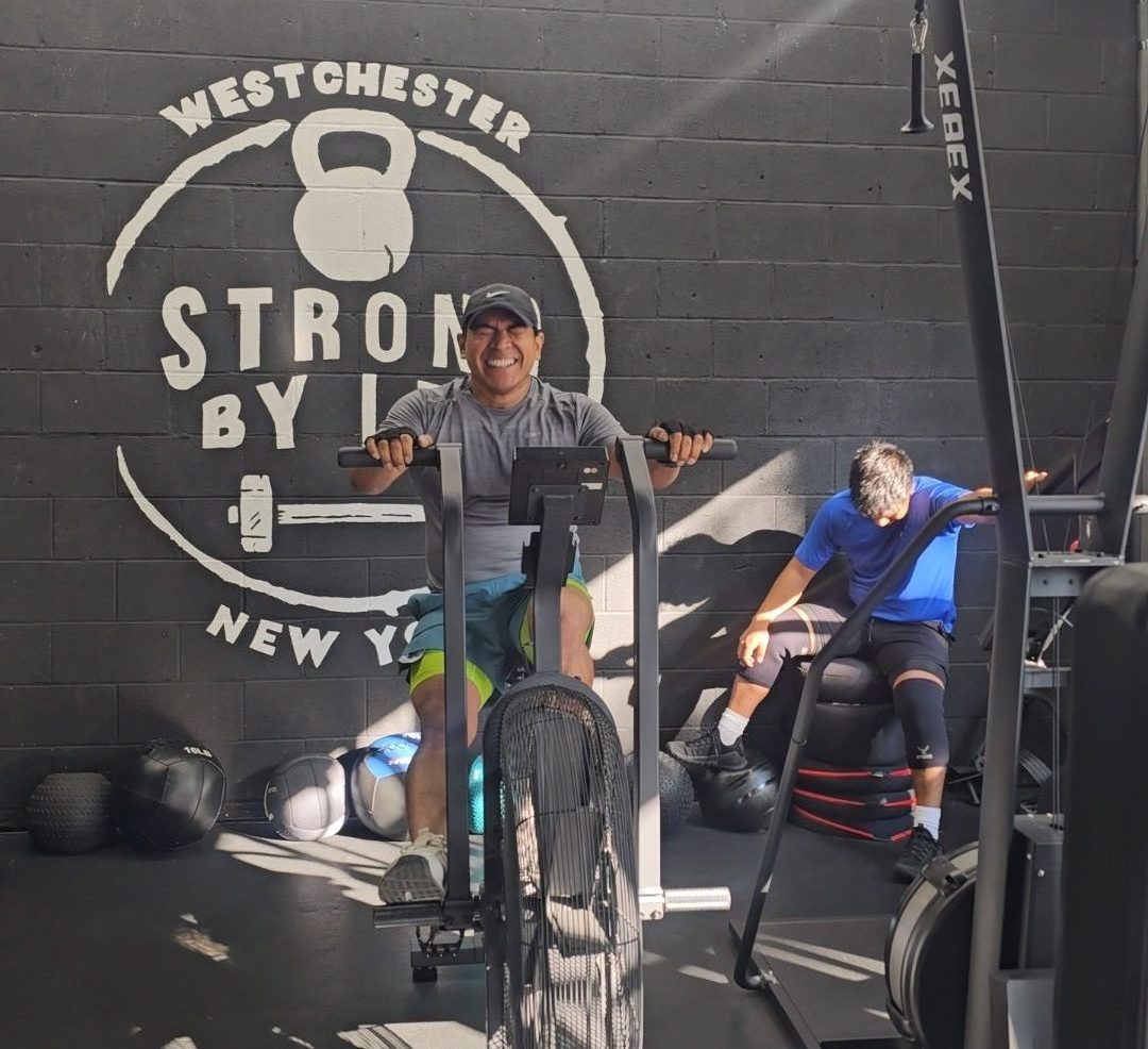 Client on air bike at Strong by Lee
